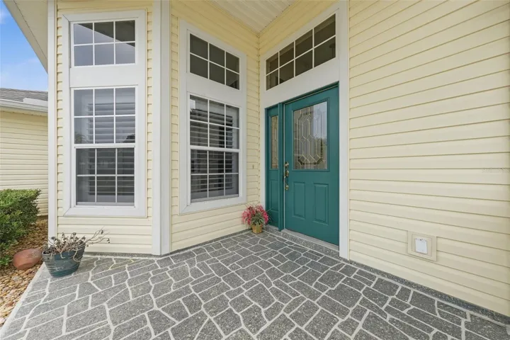 Welcoming covered entry with distinctive architectural windows and decoratice glass front door.