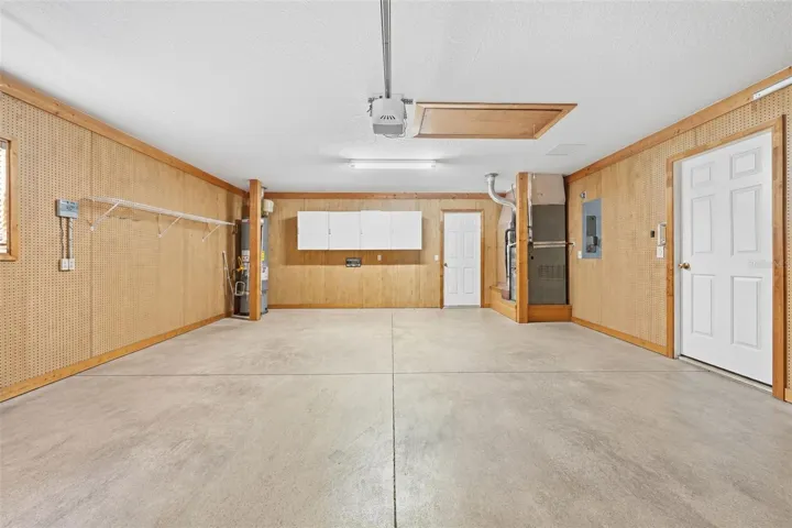 Spacious garage with built-in storage, workshop space, and convenient attic access!