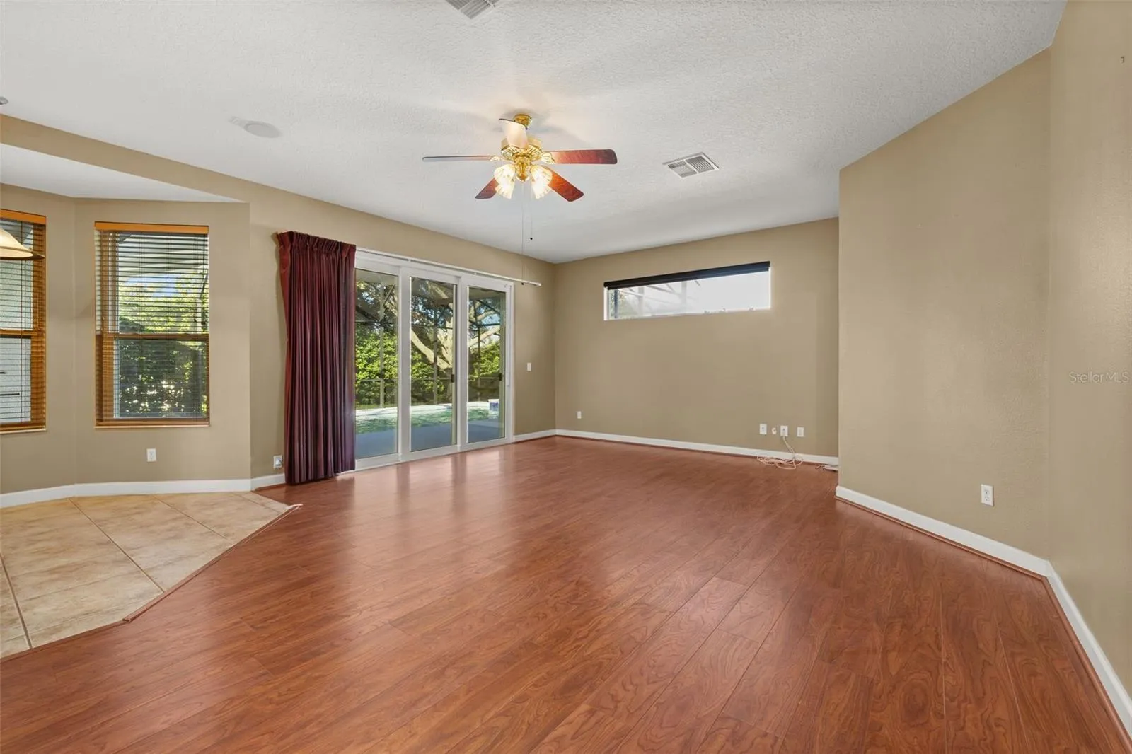 Casual open living space overlooking the pool from a wall of sliding glass doors