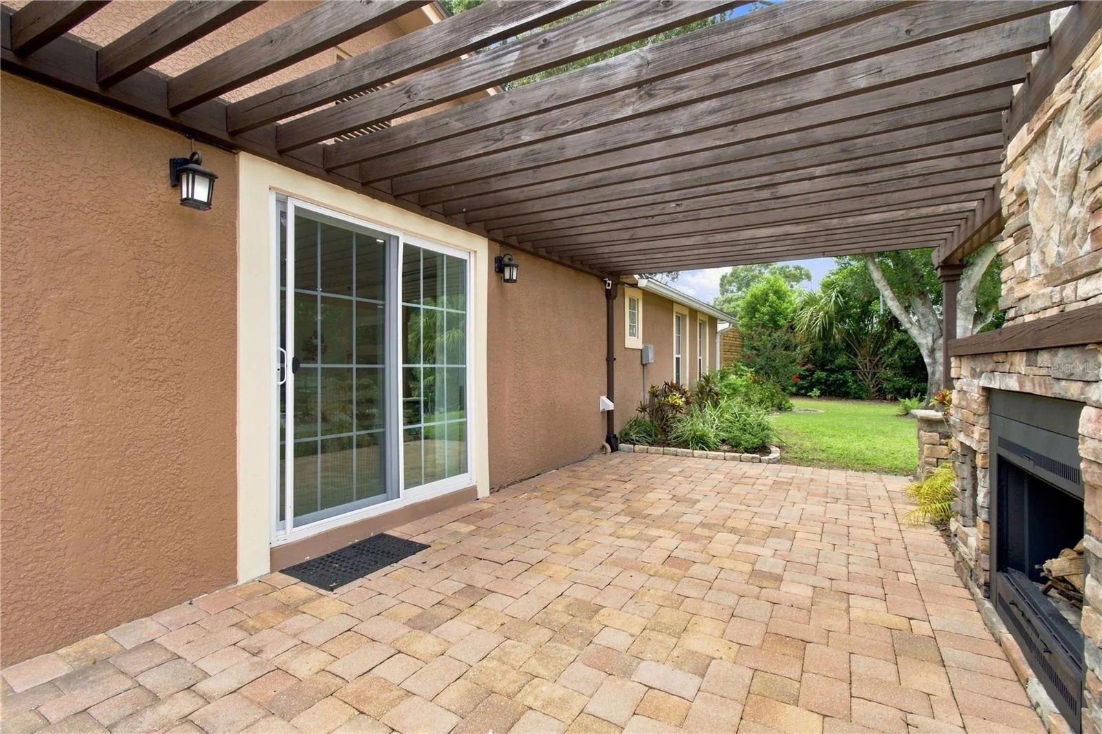Dining area sliders passage to side patio with wood fireplace