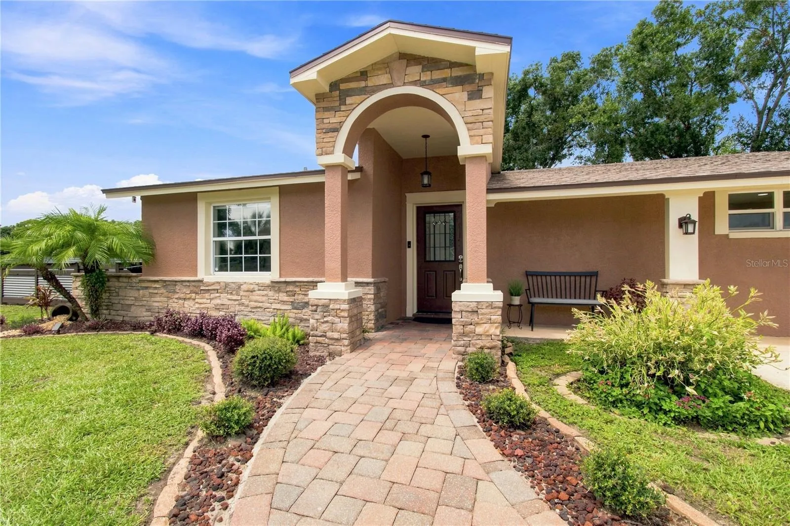 Front View warm color stone decor blends for a cohesive upgrade look, with Portico and Porch, paved walkway to complete the beautiful curb appeal.