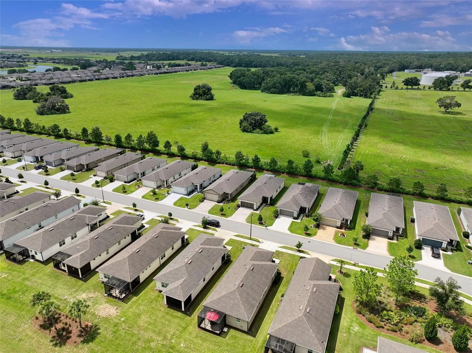 Aerial view of surrounding area from rear of home (red umbrella visible in screened cage).
