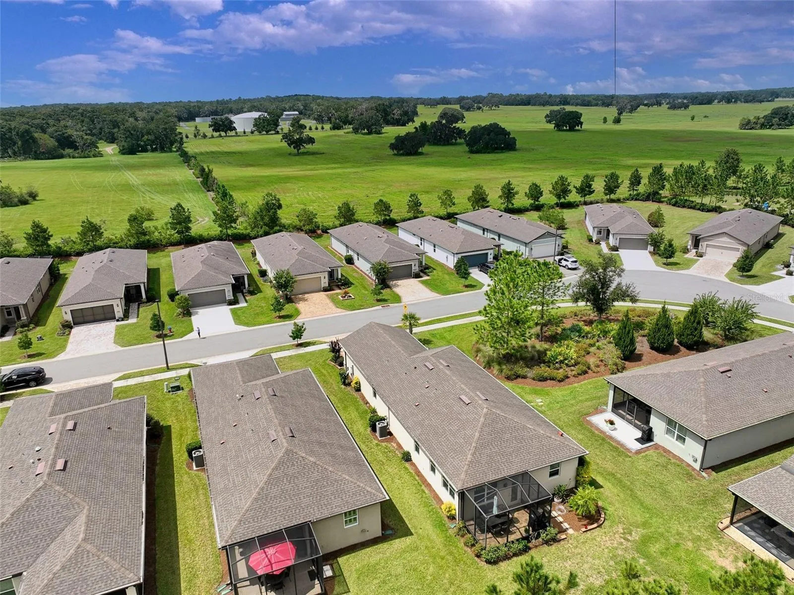 Aerial view of surrounding area from rear of home (red umbrella visible in screened cage).