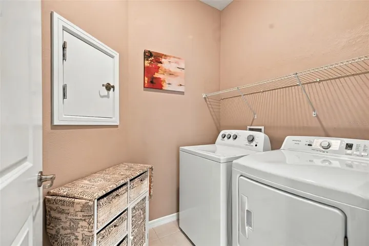Indoor Laundry Room w/washer &amp; dryer set, built-in shelf, &amp; laundry chute door to Primary Closet