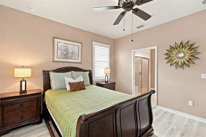 Primary Bdrm w/luxury vinyl plank floors, ceiling fan, &amp; windows w/plantation shutters