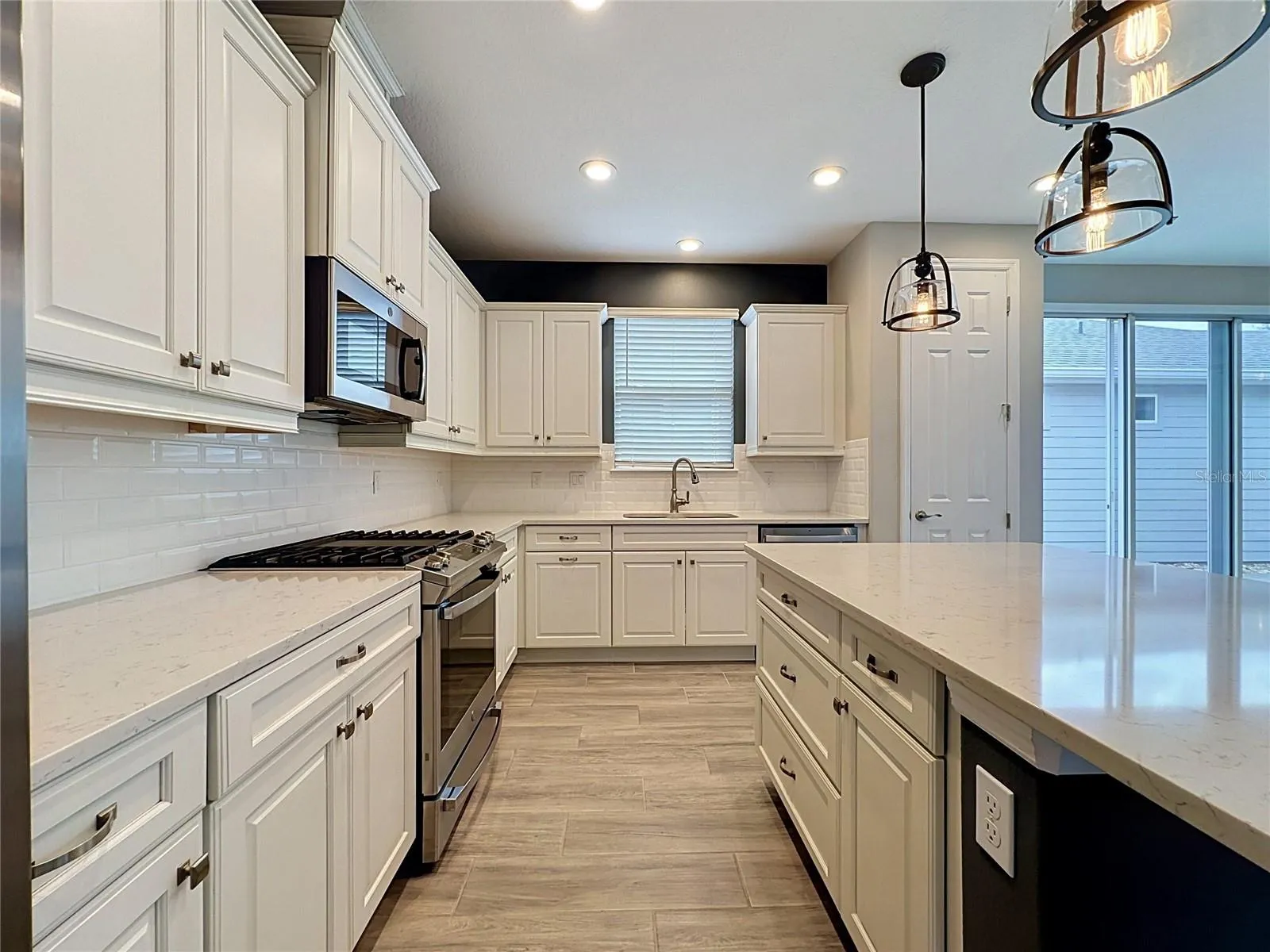GAS COOKTOP, GENEROUS KITCHEN WOOD CABINETS, POT AND PAN DRAWERS, and a convenient TRASH PULL-OUT and DECORATOR BACKSPLASH