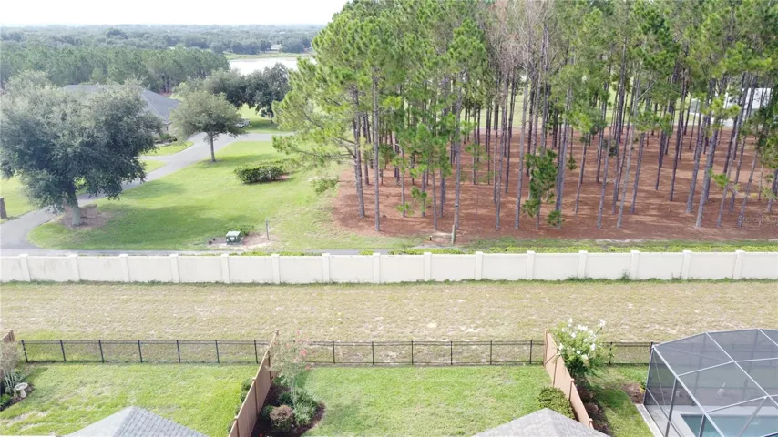 FENCED YARD LOOKS OUT TO A SCENIC WOODED SETTING