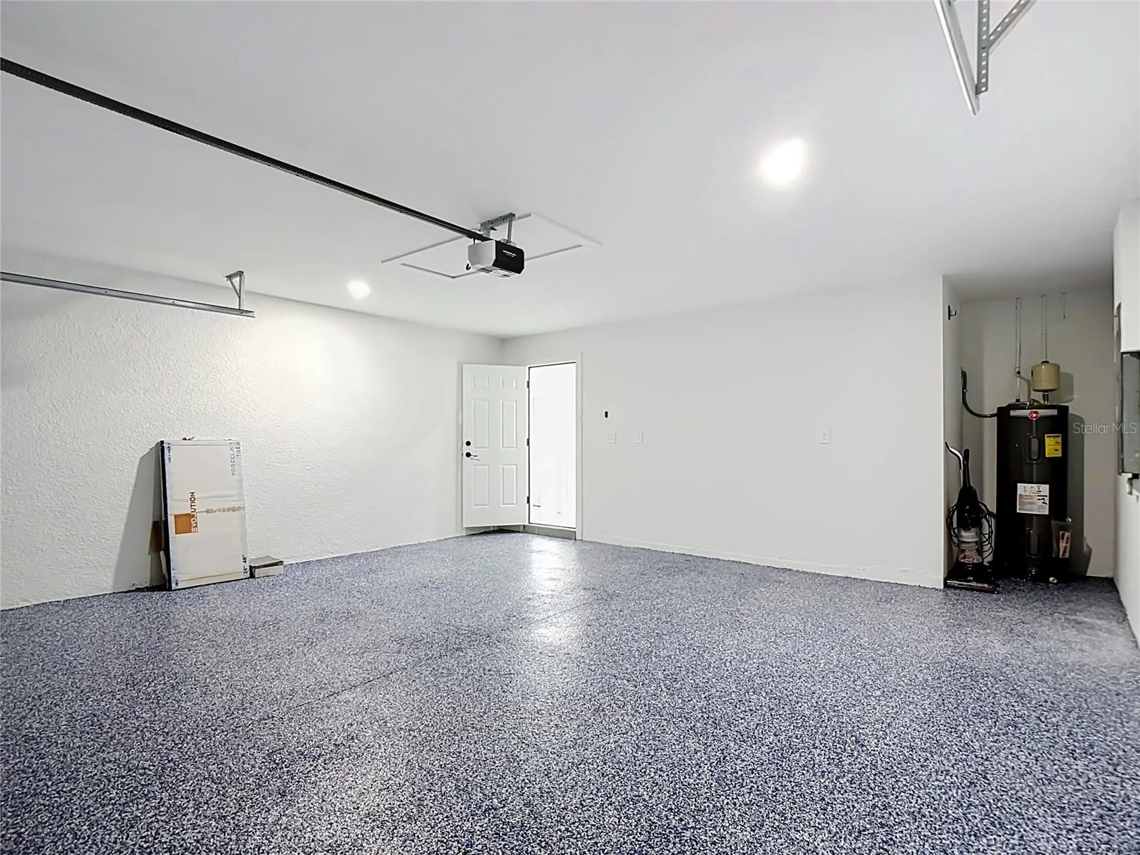 View of garage with Electric Door Opener & view of 50 gallon water tank
