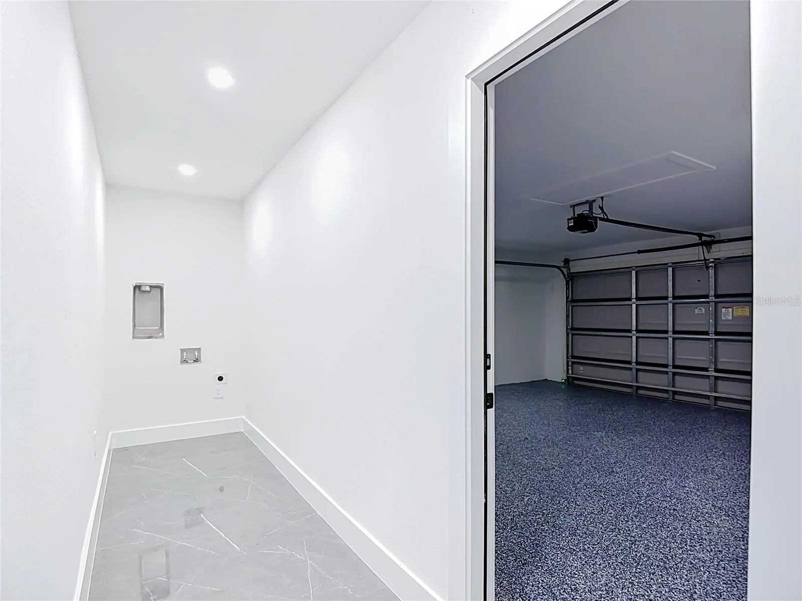 View of indoor laundry area and garage to the right