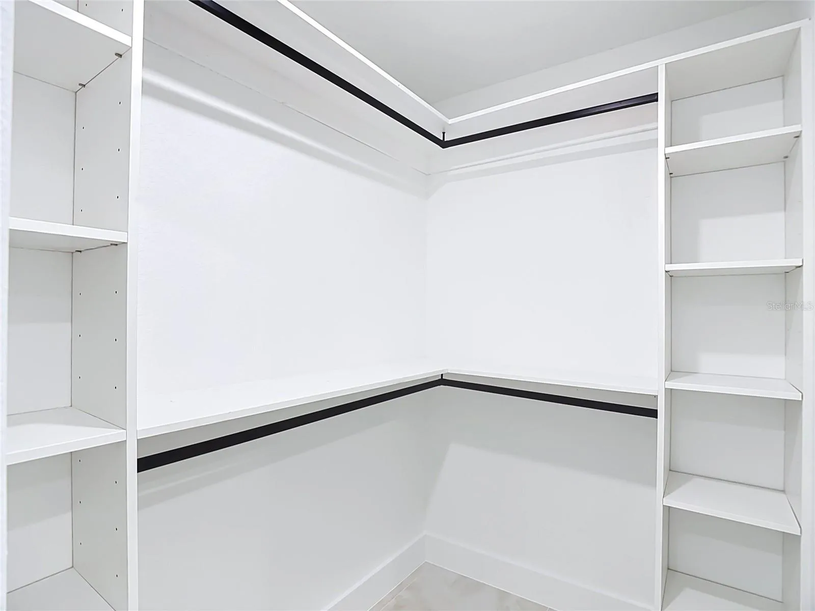 primary walk in closet with lots of shelving