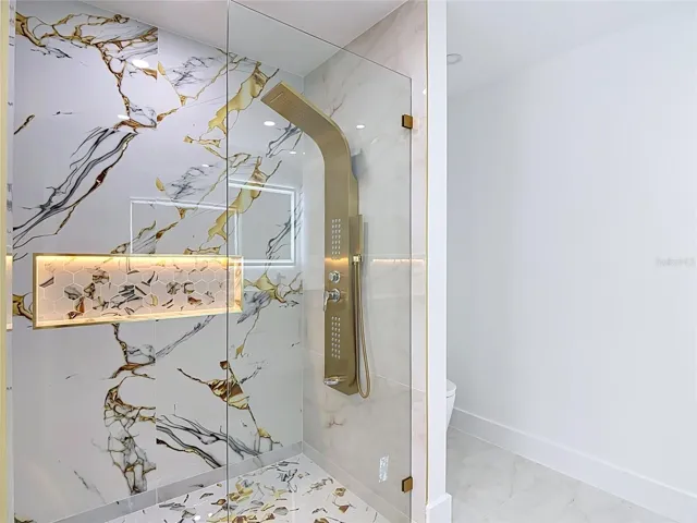 Elegant primary bathroom with tower shower and let cubby as well as the smart toilet