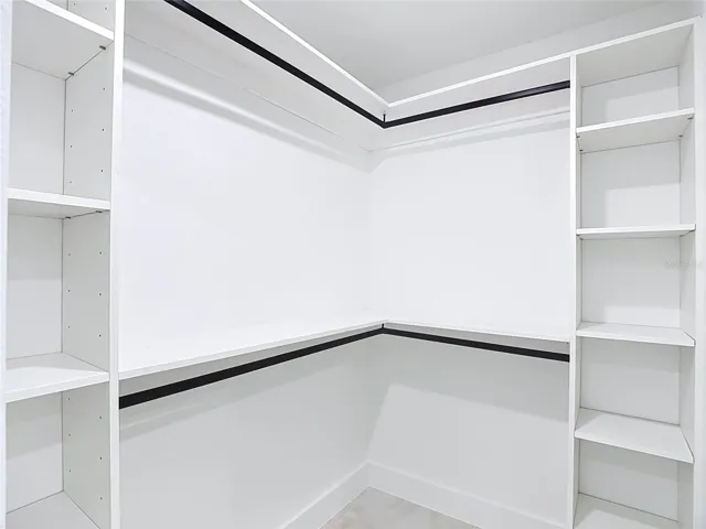 primary walk in closet with lots of shelving