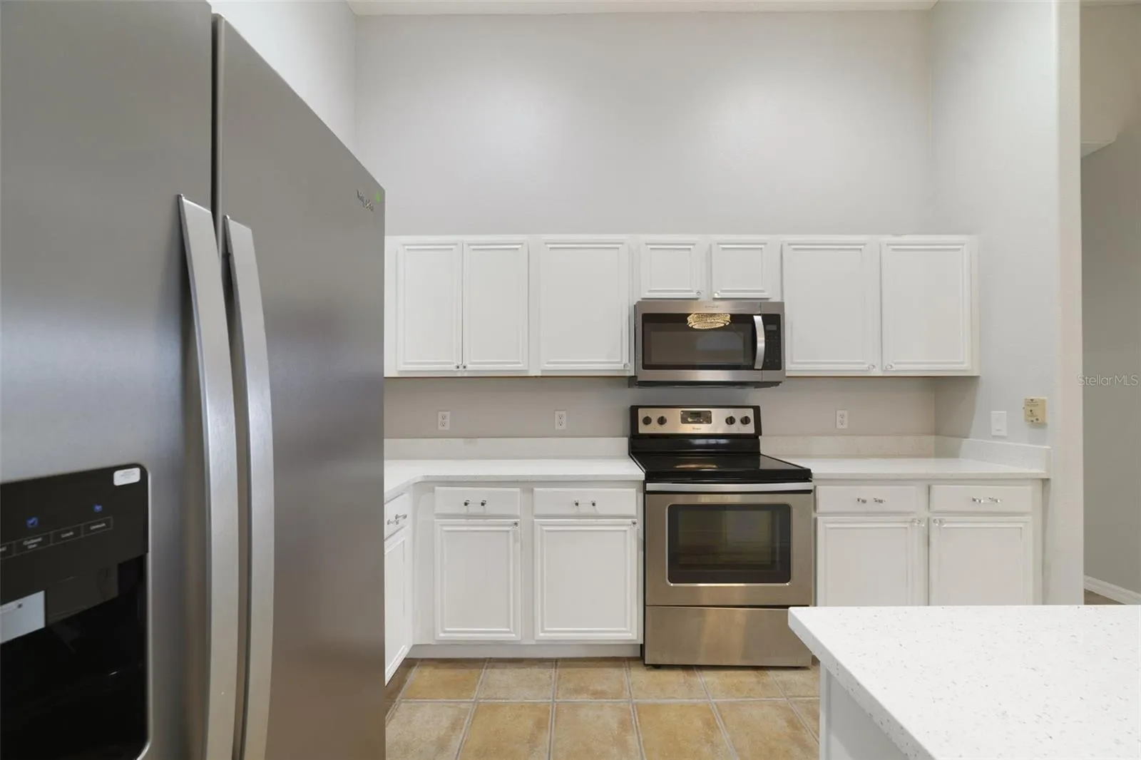 The UPDATED KITCHEN is truly the heart of the home, featuring abundant WHITE SOLID-WOOD CABINETRY, solid-surface countertops, STAINLESS STEEL APPLIANCES and a convenient BREAKFAST BAR for casual meals or entertaining.