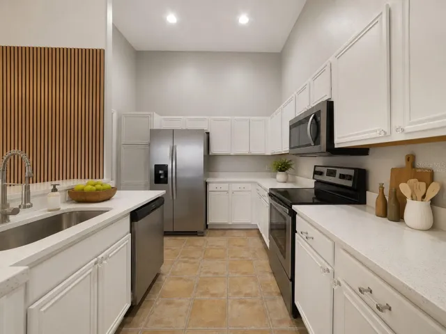 The UPDATED KITCHEN is truly the heart of the home, featuring abundant WHITE SOLID-WOOD CABINETRY, solid-surface countertops, STAINLESS STEEL APPLIANCES and a convenient BREAKFAST BAR for casual meals or entertaining. Virtually Staged