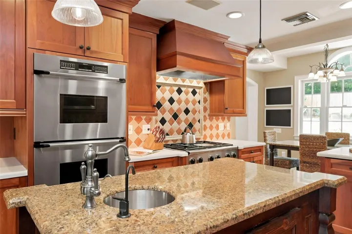 Kitchen with Gas Cooktop, Vent Hood, Built-in Ovens and Ample Countertop Space.