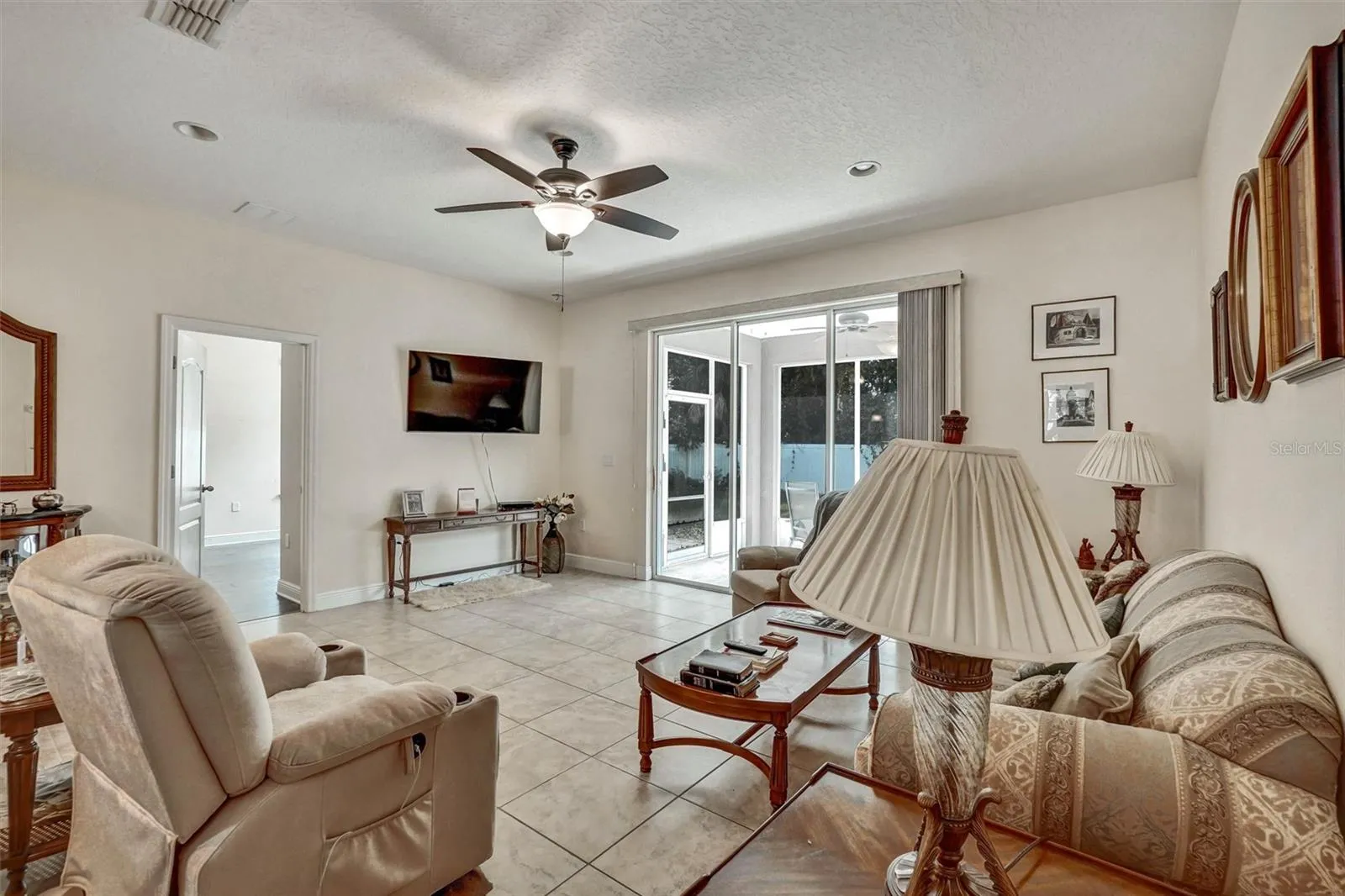 Living RoomSpacious living room with tile flooring and sliding glass doors.