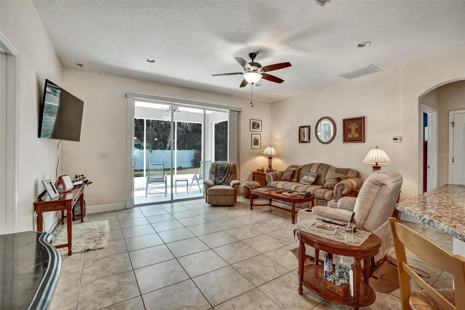 Bright living room overlooking the covered patio through sliding glass doors.