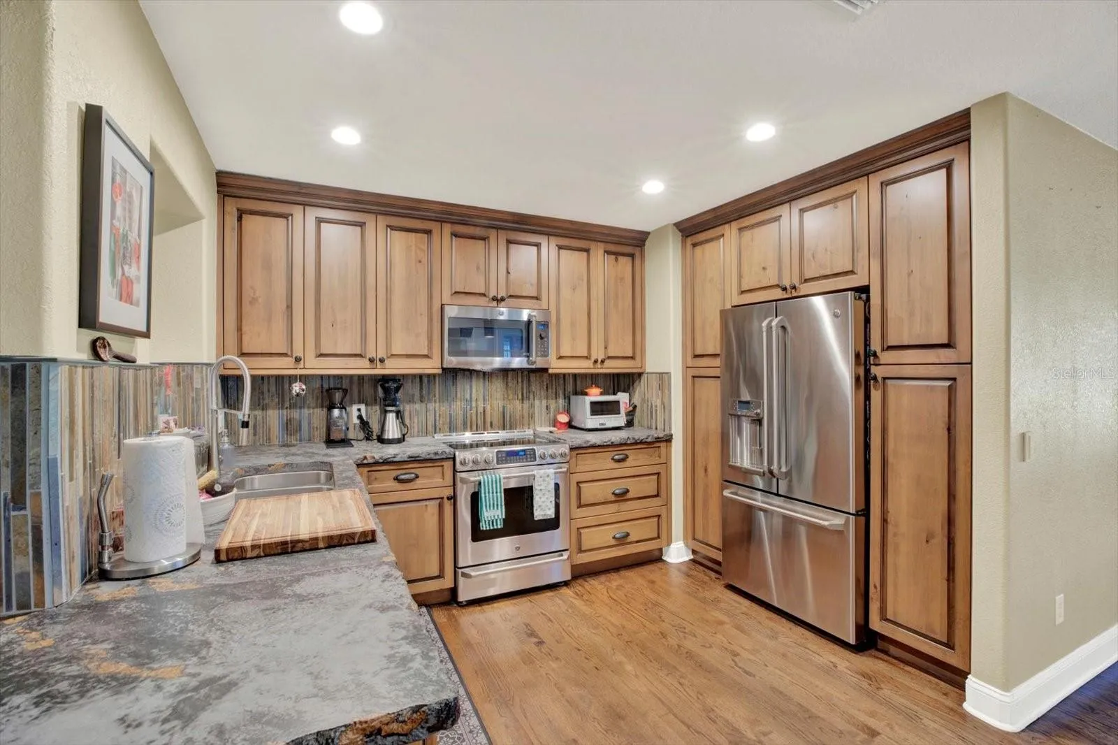 kitchen with custom wood cabinets and high-end GE Cafe stainless appliances.