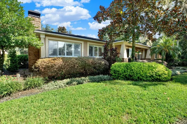 Front exterior featuring a stone chimney and classic Florida ranch styling.