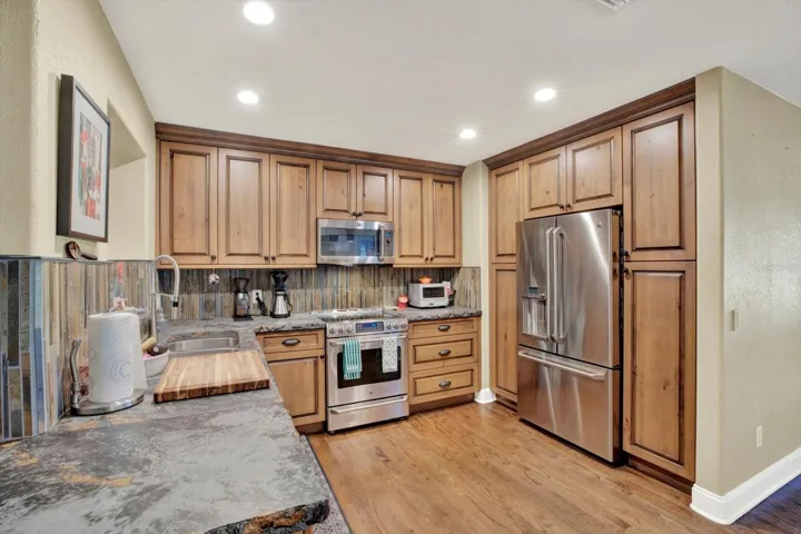 kitchen with custom wood cabinets and high-end GE Cafe stainless appliances.
