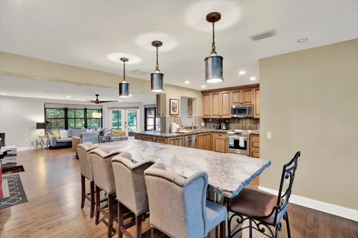 Kitchen island bar seating opens to the living and dining areas.