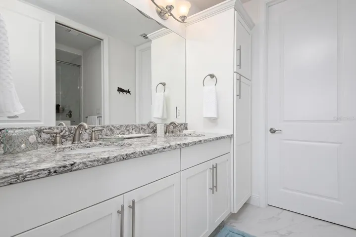 primary bath with double vanities and linen closet
