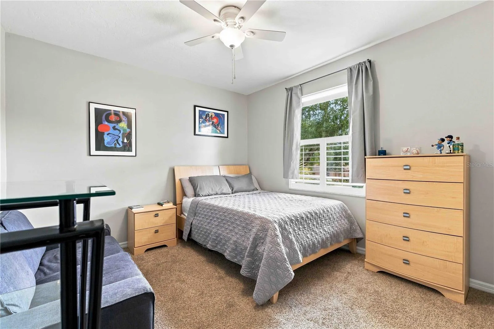 A comfortable secondary bedroom with a large window, ample closet space, and room to make it your own