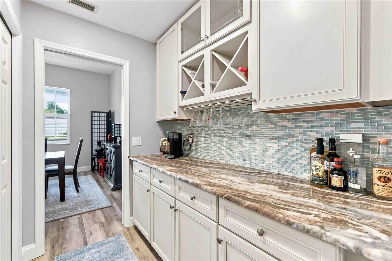 A fully equipped butler's pantry with glass-front cabinetry, wine storage, and a stemware rack — perfect for entertaining