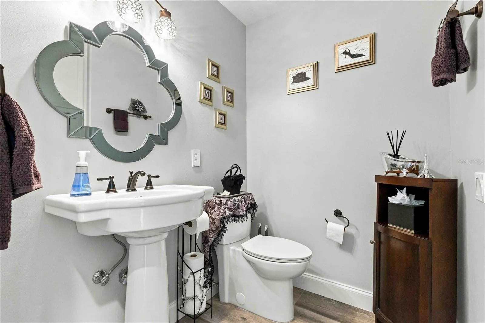 A charming first floor powder bath with a pedestal sink and ornate mirror — a lovely touch for guests