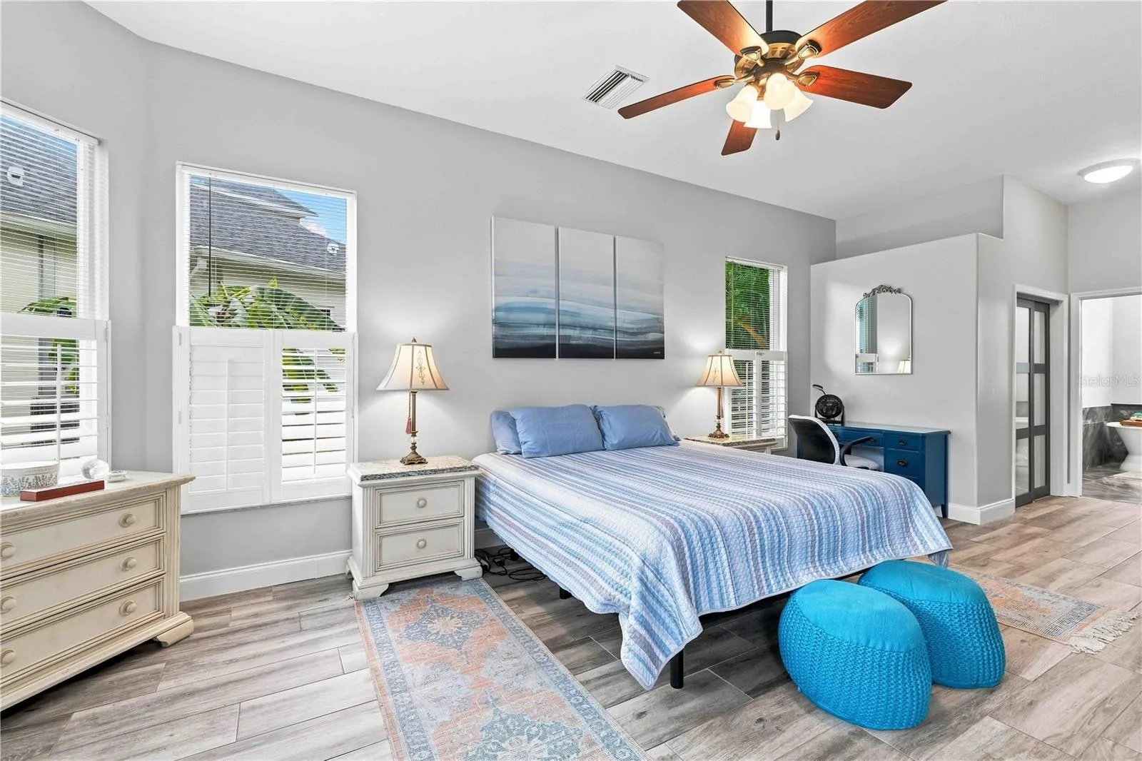 Multiple windows and a private sitting nook make this primary suite feel like its own wing of the home