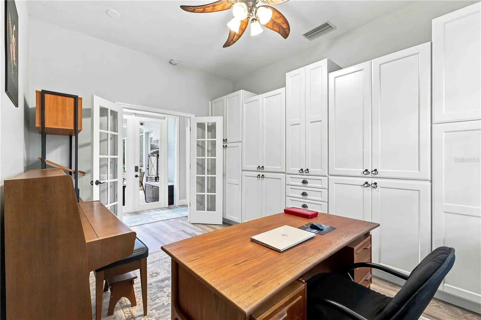 French doors bring in natural light and lanai views from this well-appointed office retreat