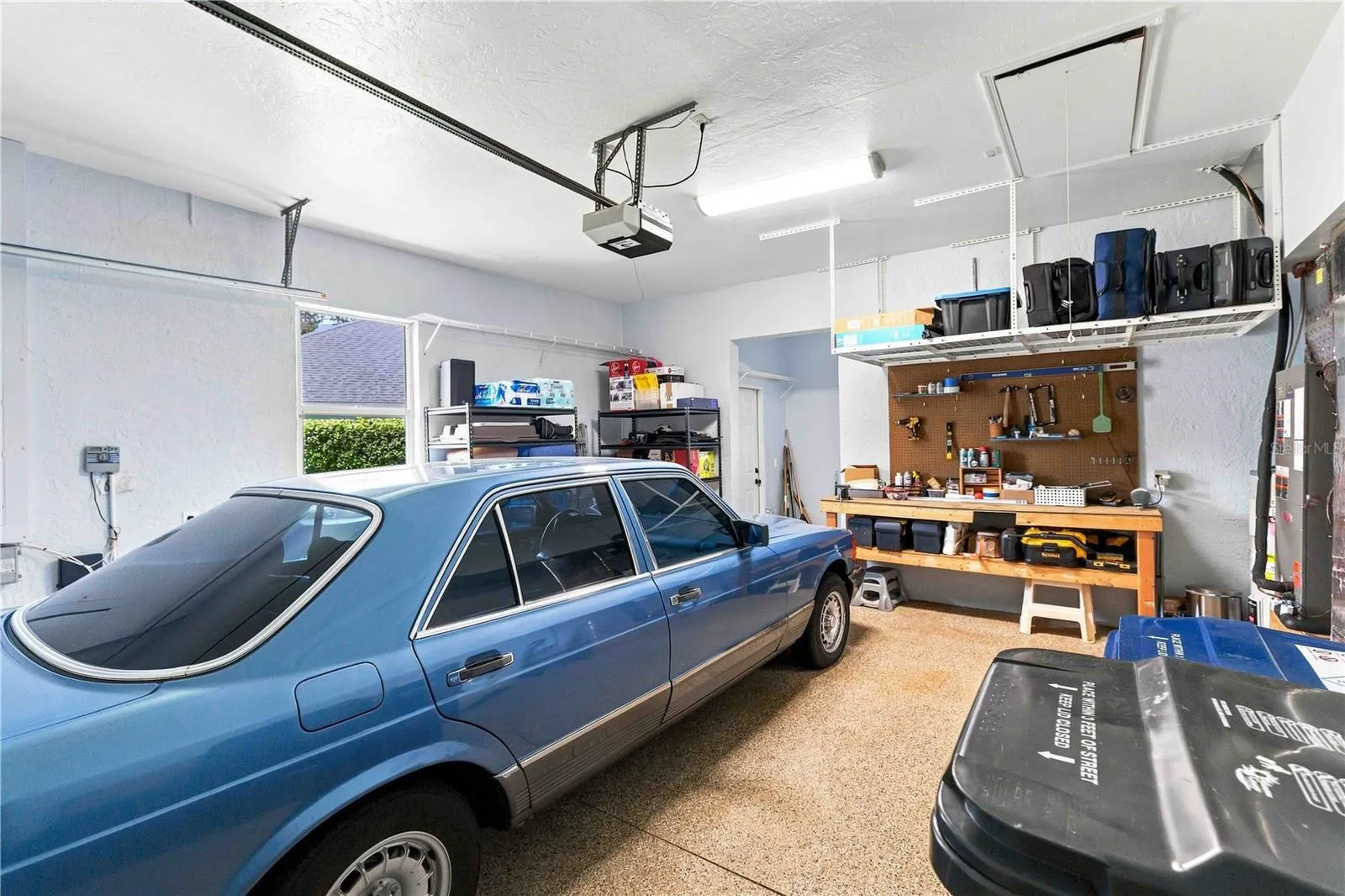 A two-car garage with built-in workbench, pegboard, and overhead storage racks — plenty of room for tools and projects