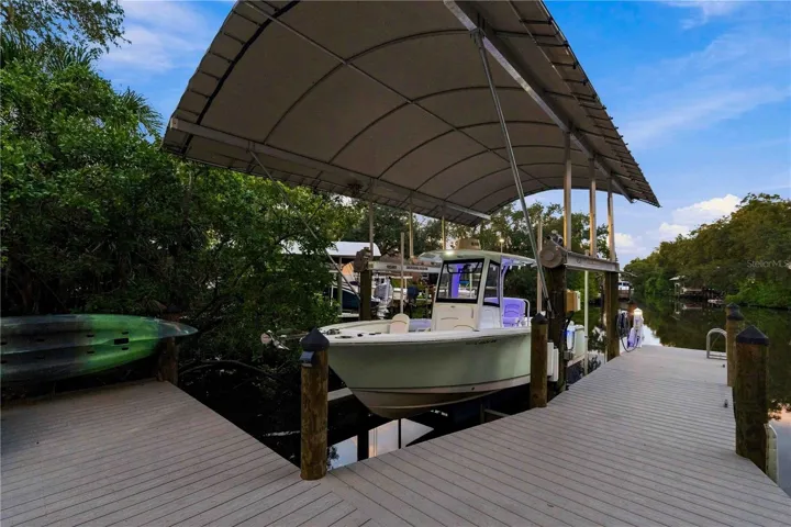 The commercial-grade dock and covered boat lift open straight onto the canal — kayaks included, ready for a day on the water