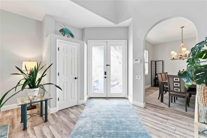 The artist-commissioned glass entry doors are even more stunning from inside, framed by soaring ceilings and an open flow into the dining room