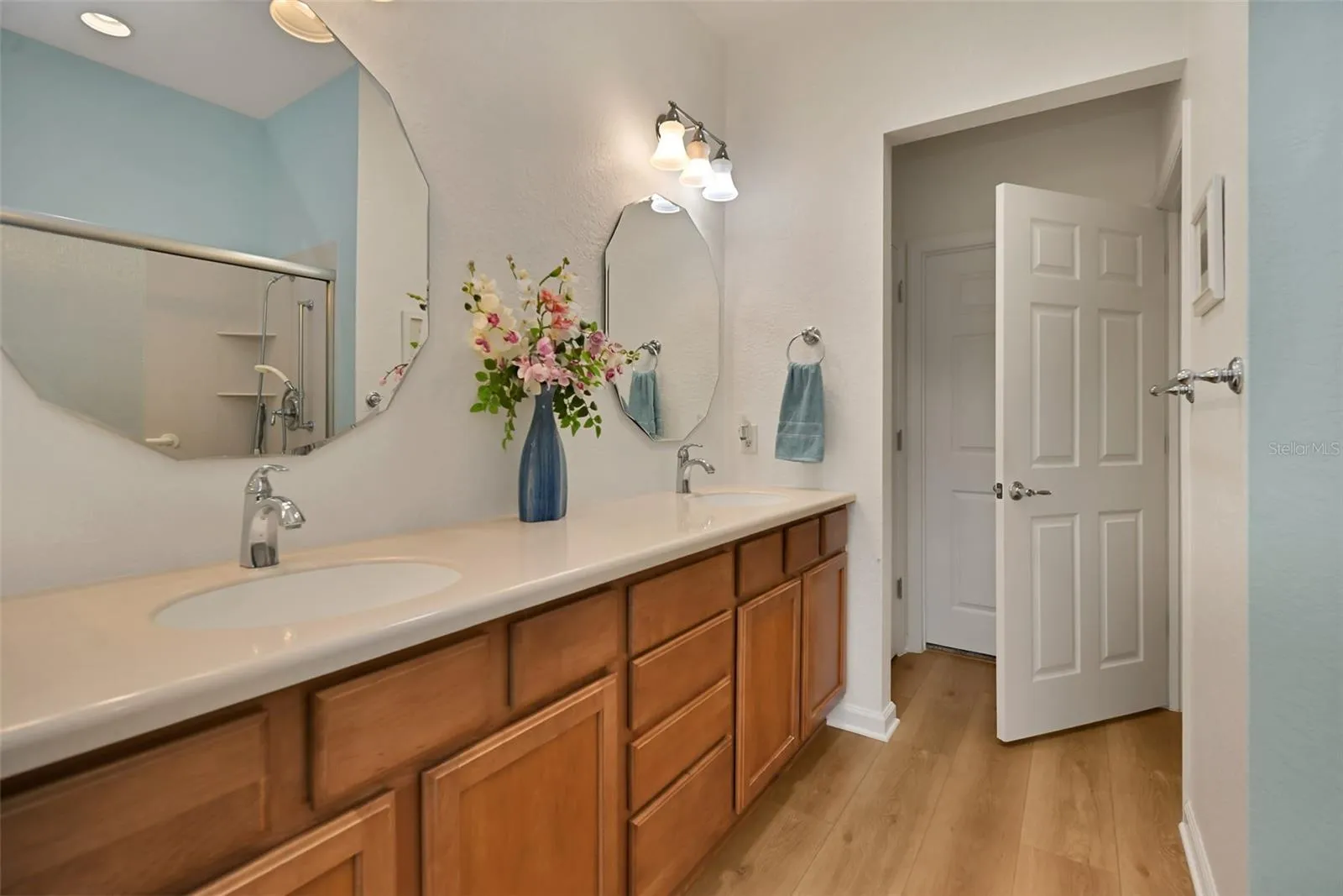 Primary ensuite bath with double vanity, walk-in shower, private commode, linen closet & walk-in closet