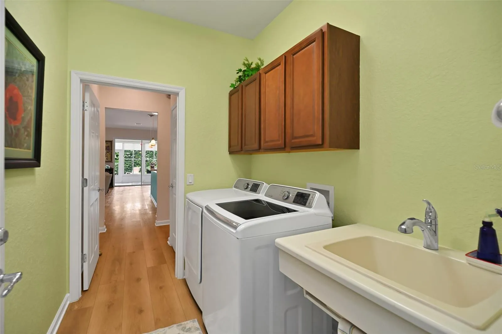 Laundry room with washer, dryer, cabinets, and utility sink