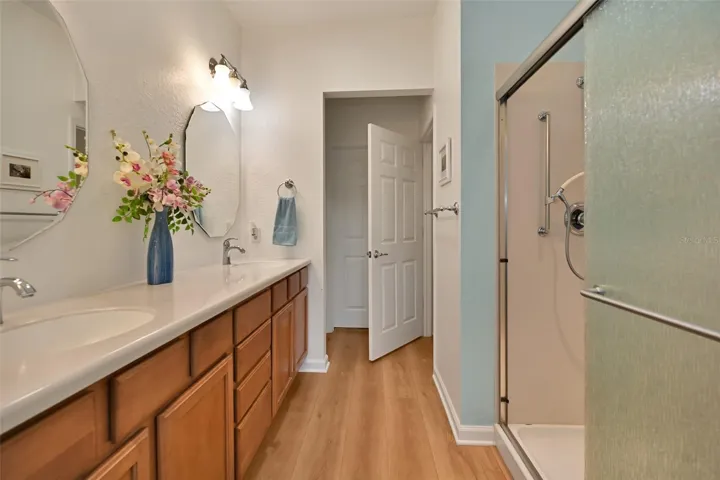 Primary ensuite bath with double vanity, walk-in shower, private commode, linen closet & walk-in closet