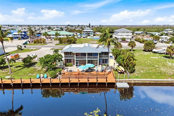 The expansive waterfront deck creates an inviting gathering space for guests to relax, entertain, enjoy beautiful sunsets, and watch for dolphins along the canal.