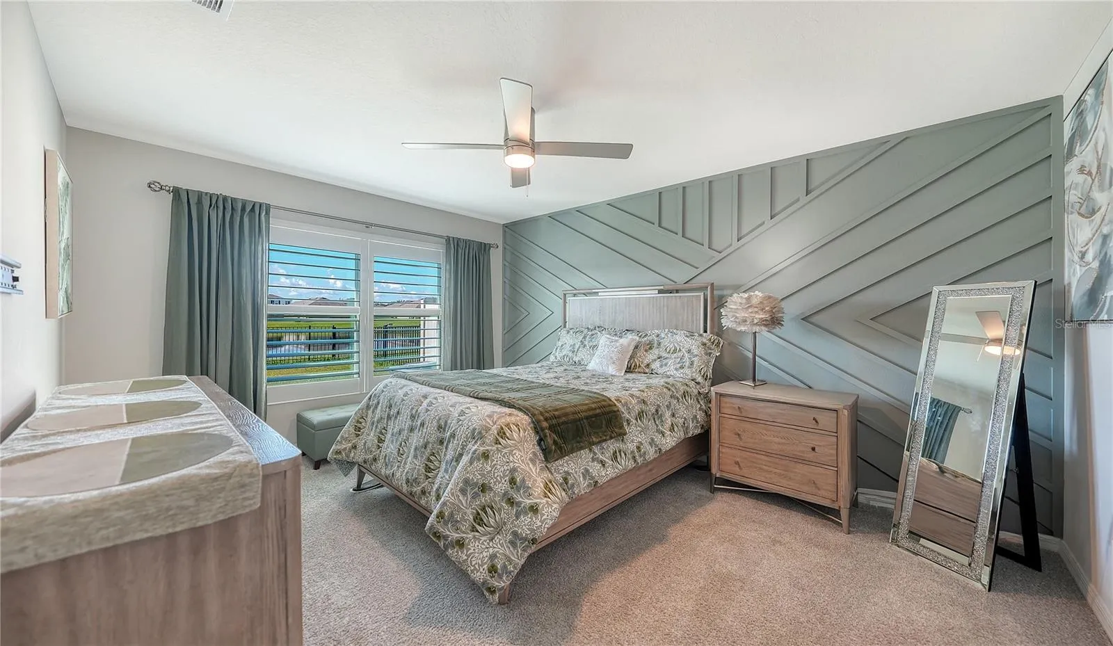 Primary bedroom overlooking the pretty pond and the water fountain at the back of the home.