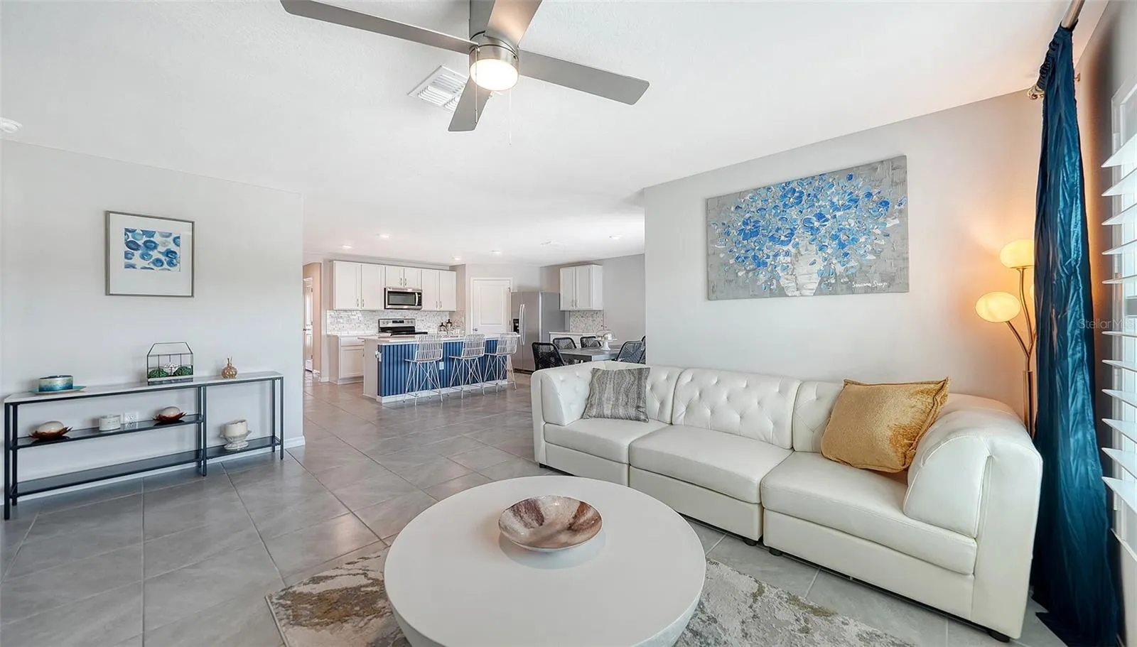 Great room looking into the kitchen with an upgraded ceiling fan.