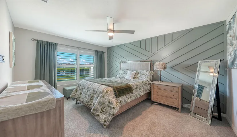 Primary bedroom overlooking the pretty pond and the water fountain at the back of the home.