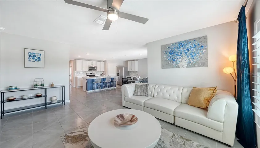 Great room looking into the kitchen with an upgraded ceiling fan.