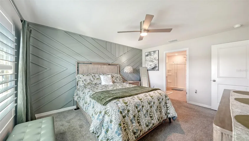 Upgraded designer wall and ceiling fan in the primary bedroom.