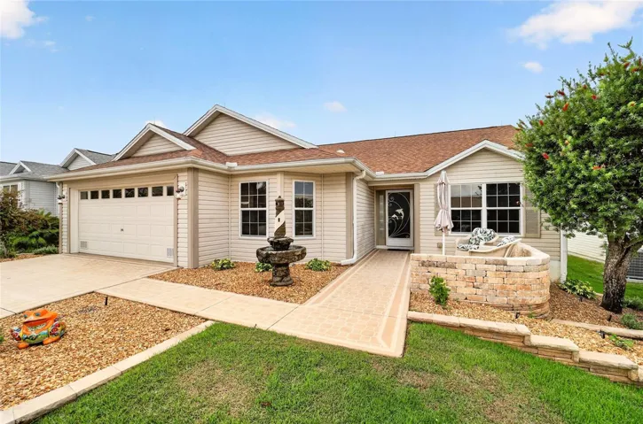 Front Exterior: Single-story exterior with an attached garage, covered entry, decorative hardscaping, and a welcoming front patio area.