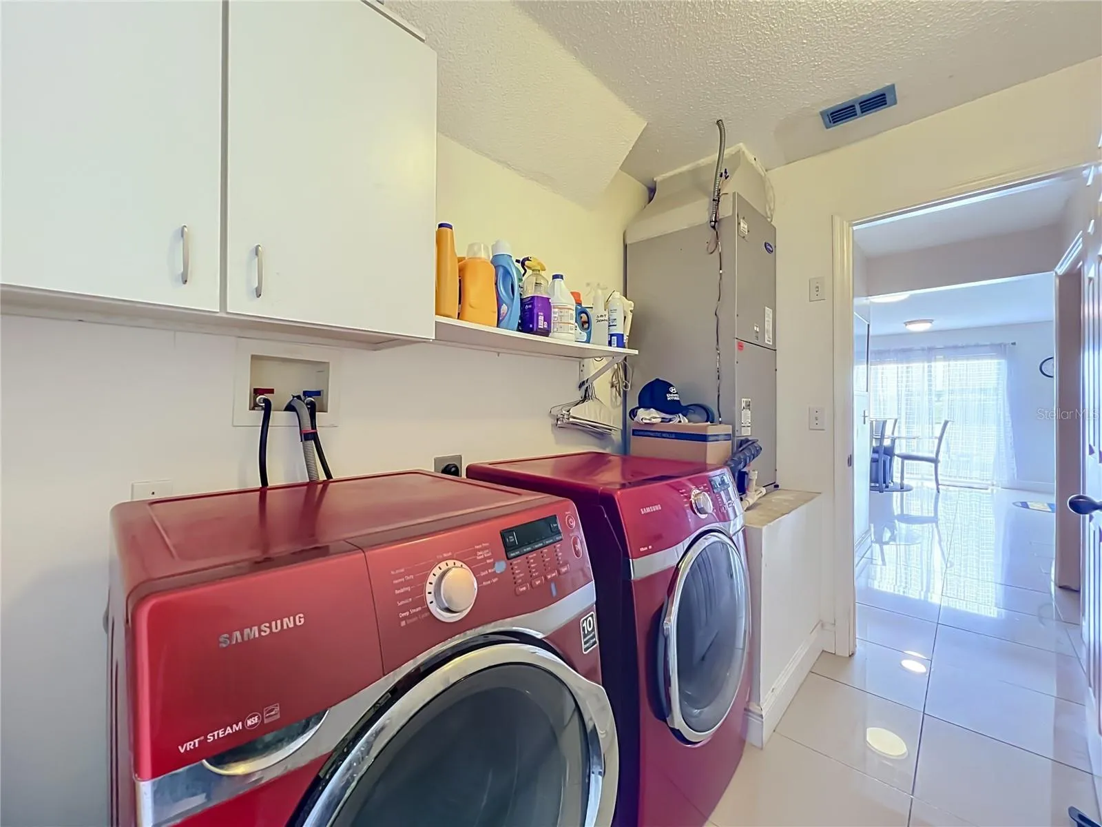 Off the kitchen is the 1st floor inside laundry room with nice Samsung washer and dryer, storage cabinets and storage shelf