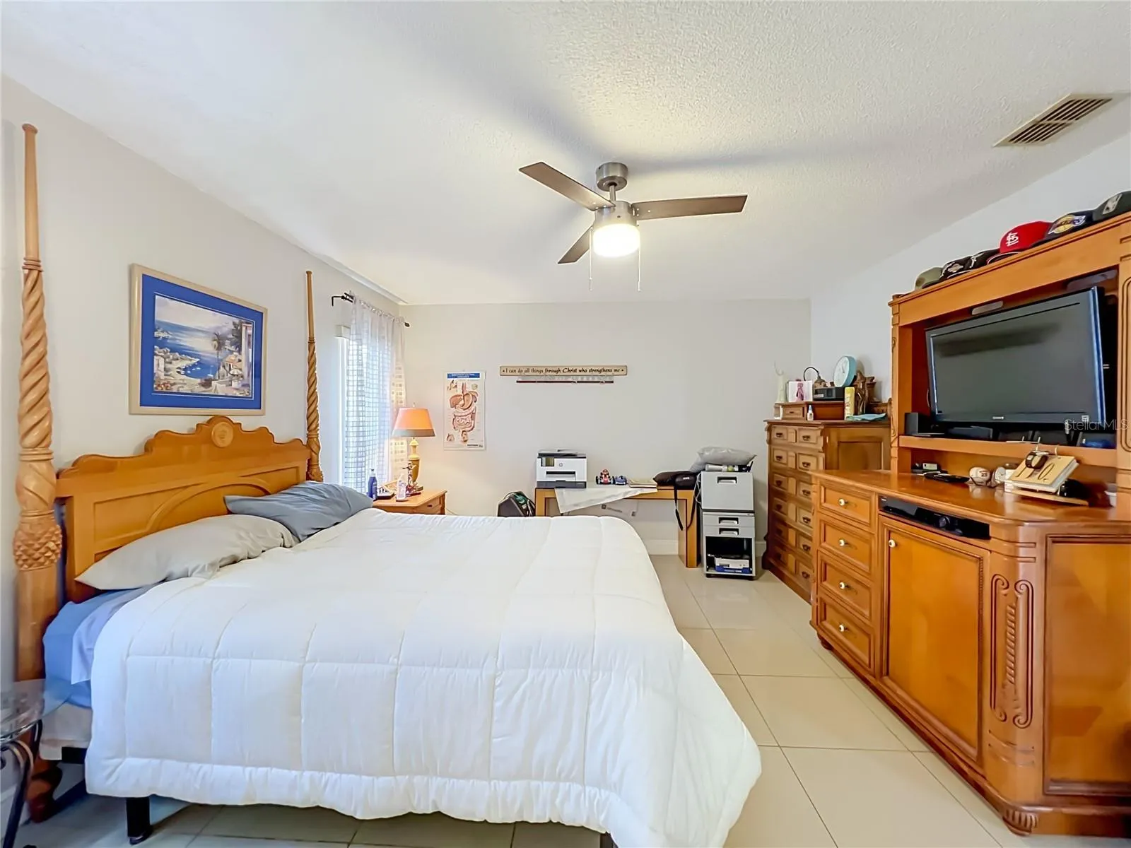 Primary bedroom on 1st floor with ceiling fan and ceramic tile floor