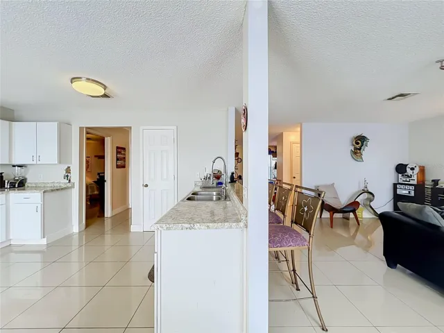 Kitchen and Family room show hallways to Primary bedroom on the left and to the 1/2 bath leading to front of the house