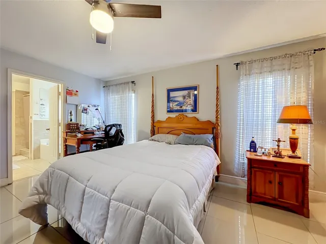 Primary bedroom on 1st floor with ceiling fan and ceramic tile floor