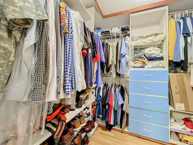 Wood floors and built in drawers and shelving in the large walk in Primary closet