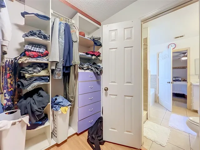 Wood floors and built in drawers and shelving in the large Primary walk in closet